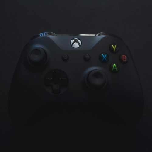Xbox controller illuminated against a dark background, perfect for gaming themes.